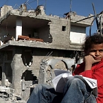Palestinian teenager outside her destroyed home